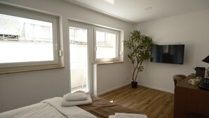 A hotel room with a bed, a desk, a television, and a window. - The Haus KAI Nuremberg (Nuremberg)