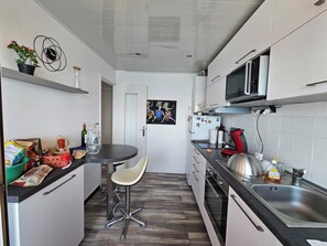 Eine moderne Küche mit Barhocker, Mikrowelle und Spüle.