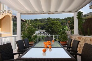 An outdoor patio with a table, chairs, and a view of a hillside. - Country Home "Can Medina" close to the Beach with Pool, Terrace & Garden (Cala Sant Vicenç)