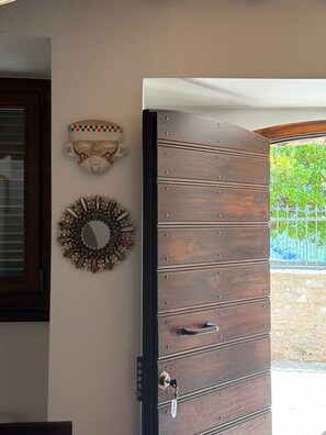Une porte en bois, dotée d’une poignée et d’un trou de serrure, flanquée de deux éléments décoratifs fixés au mur.