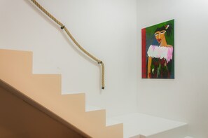 Un escalier avec une main courante en corde menant à un palier.