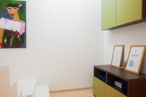 Une pièce avec un meuble vert, un certificat encadré et un tableau accroché au mur.