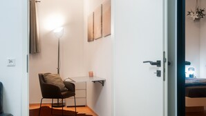 A room with a desk, chair, and a hanging light fixture.