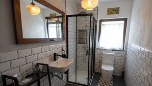 A bathroom with a glass-enclosed shower, a sink, a toilet, and a mirror with a wooden frame. - House by the sea in the most beautiful village of Asturias!!! (Muros de Nalón)