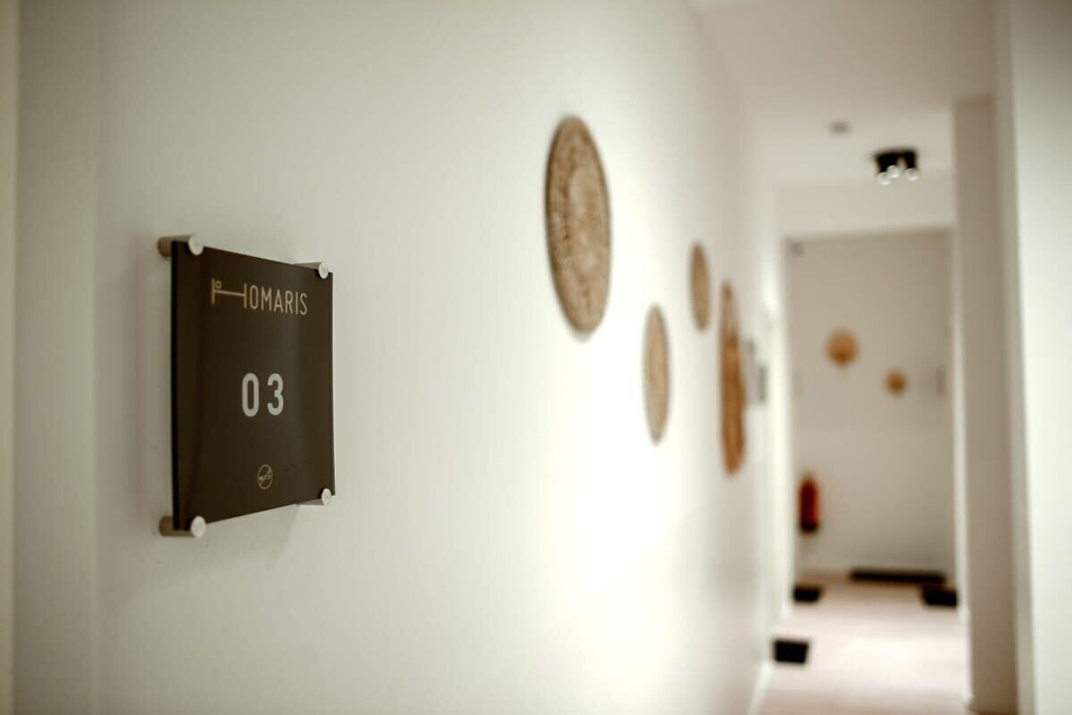Ein Flur mit einem Schild, auf dem 'IOMARIS 03' steht, und mehreren runden Wanddekorationen.