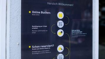 Ein Schild für Apartments mit Anleitungen zur Online-Buchung und zum Check-in.