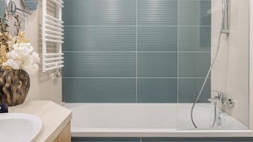 A modern bathroom with a bathtub, a shower, and a vanity with two sinks.