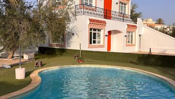 Un bâtiment à deux étages avec une piscine devant.