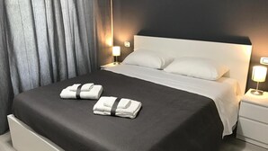 Una habitación de hotel con una cama grande, dos lámparas de noche y una cortina.