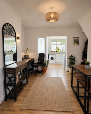 A modern kitchen with a view to the outdoors, a dining area with a table and chairs, a large mirror, and a hanging light fixture. - Room-cozy Guest Room in Vibrant Brighton (Brighton)