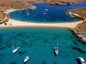 Eine Küstenregion mit klarem türkisblauem Wasser, Booten und einem Sandstrand.