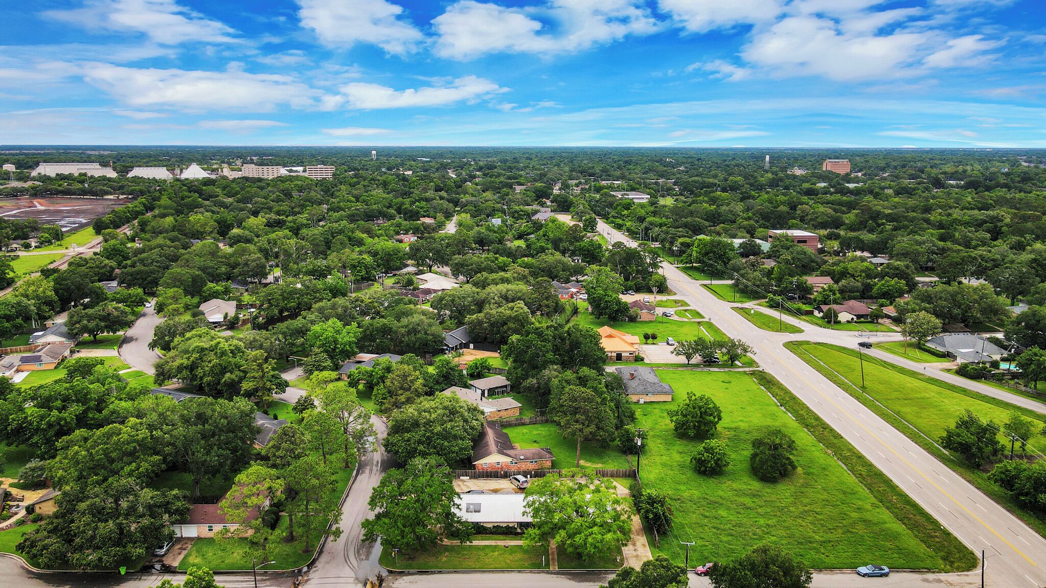 An aerial view of a residential area with houses, roads, and greenery.