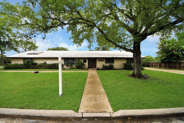 A house with a front yard, a sidewalk leading to the entrance, and a tree providing shade. - Lofty Grace Home 2 (Richmond)