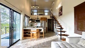 Eine moderne Küche mit Essbereich, einer Treppe und einer großen Schiebeglasdoor.