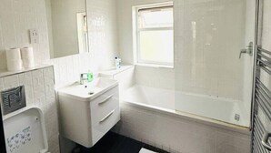 Un baño con inodoro, lavamanos, tocador, bañera y zona de ducha.