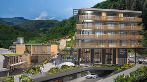 Un hotel moderno con varios balcones, un patio central y vistas de las montañas circundantes.