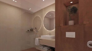 A modern bathroom with a glass shower enclosure, a white sink, and a mirror with circular frames.