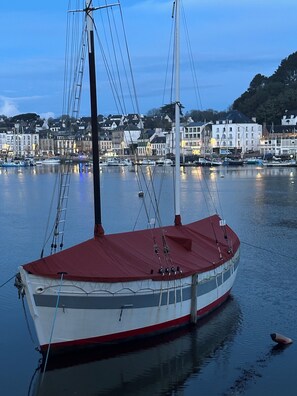 A boat docked at a harbor with buildings in the background. - Port & sea view - Elegant apartment for 2 in Audierne - L'Oasis sur mer (PLOUHINEC)