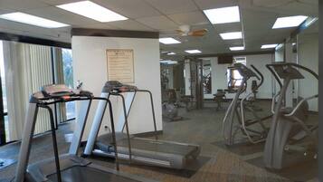 A gym with treadmills, elliptical machines, and weight equipment.