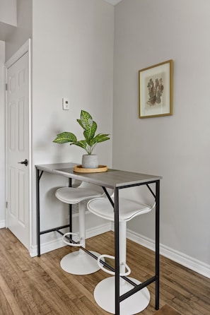 A modern kitchen with a grey countertop, white cabinetry, and a potted plant. - Walkerville Windsor | 3BR | 2 Private Apartments | Sleeps 6 (Windsor)