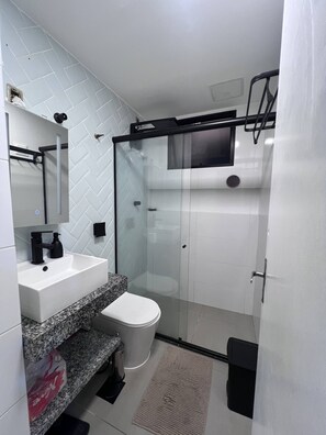 Een douche, een bidet, handdoeken, toiletpapier