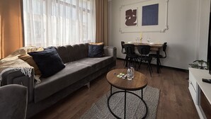 Ein modernes Wohnzimmer mit einer Couch, einem Esstisch, Stühlen und einem Couchtisch.