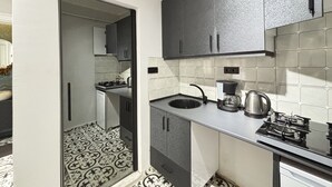 Eine moderne Küche mit Gasherd, Spüle und Kaffeemaschine.