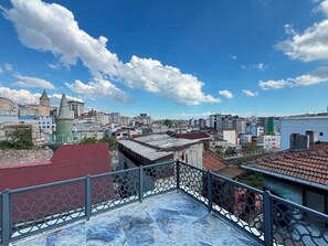 Eine Dachterrasse mit Blick auf eine Stadtlandschaft, darunter verschiedene Gebäude und eine Moschee.