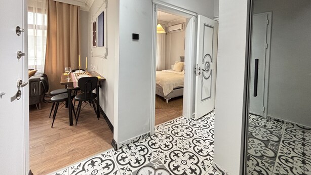 A hotel room with a bed, a bedside table, a chair, and a window with curtains. - Unique 1BR w/ Hammam • Near Şişhane - Galata (Istanbul)