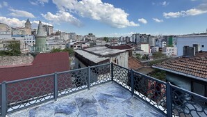 A rooftop terrace with a view of a cityscape, including buildings and a tower. - Unique 1BR w/ Hammam • Near Şişhane - Galata (Istanbul)
