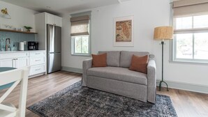 Un salon moderne avec un canapé gris, une table basse et un lampadaire.