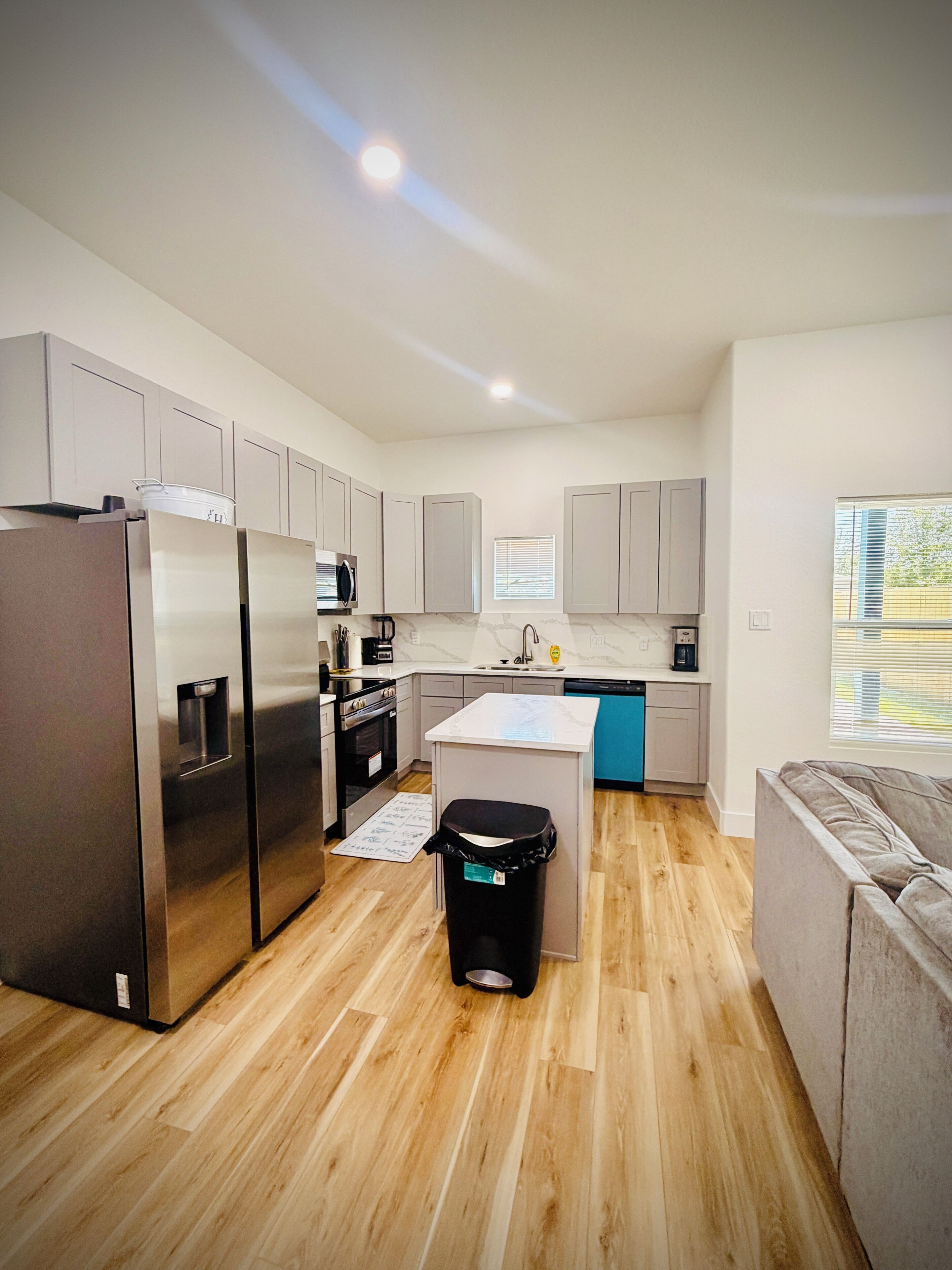 A modern kitchen with stainless steel appliances, a central island, and a built-in oven.