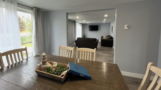 Un coin repas avec une table en bois, des chaises, un plateau de nourriture et un dossier bleu.