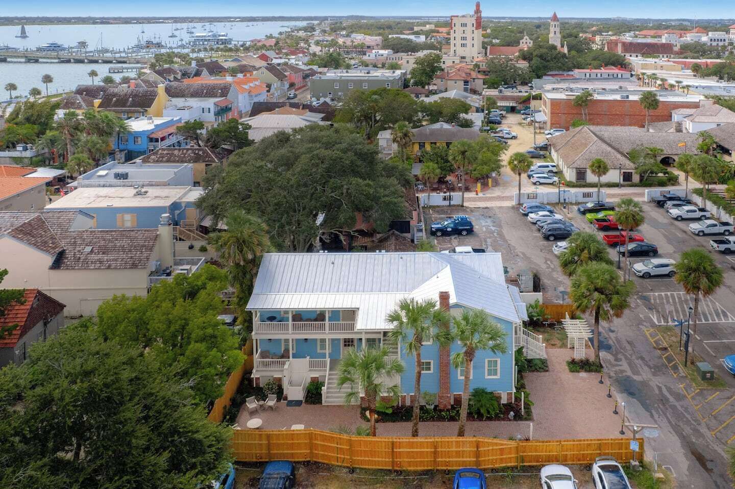 Une ville côtière qui se distingue par un imposant bâtiment bleu, un port de plaisance et le clocher d’une église.