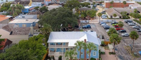 Une ville côtière qui se distingue par un imposant bâtiment bleu, un port de plaisance et le clocher d’une église.