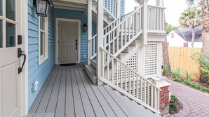 A porch with a white railing, a door, and a blue exterior wall. - Luxury Boutique Hotel | All 8 Suites | Sleeps 24 | Steps from St. George Street! (St. Augustine)