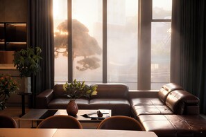 Ein modernes Wohnzimmer mit Ledersofa, Couchtisch und einer Topfpflanze.