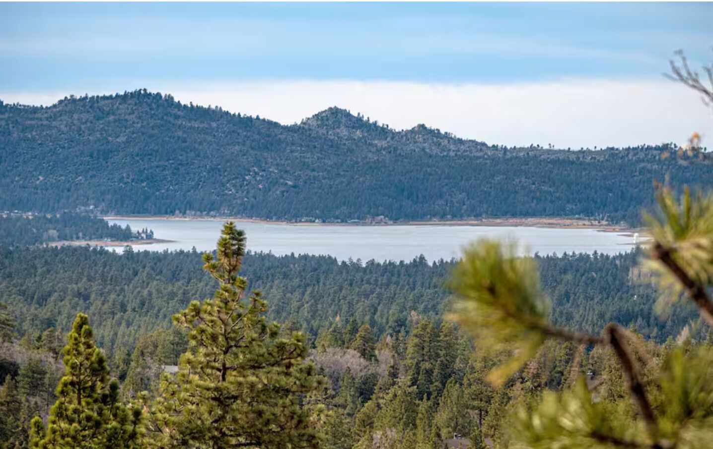 A mountainous landscape with a lake and dense forest.