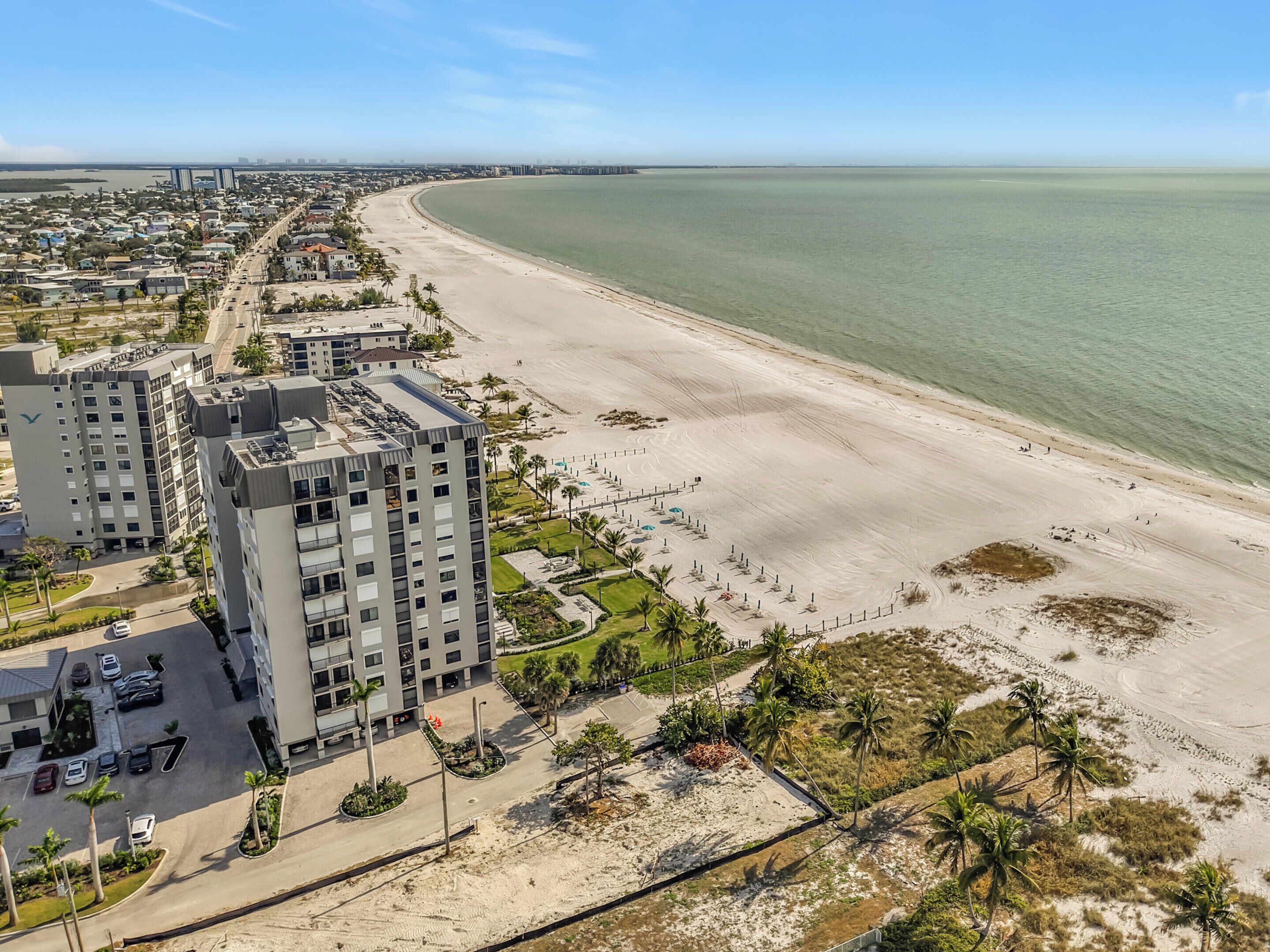 Un hôtel situé sur la côte, avec plusieurs étages, un parking et une vue sur la plage.