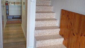 A staircase with a wooden handrail, a bathroom with a mirror, and a wooden floor. - Country apartment close to the Dolce Via and hiking trails (Saint-Agrève)
