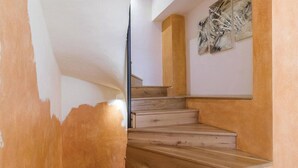 A staircase with wooden steps and a handrail, leading to a landing with a wall-mounted artwork. - Holiday house in a peaceful village (Svetvincenat)