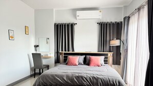 A modern bedroom with a bed, a desk, and an air conditioning unit. - Your ultimate modern escape awaits at NS House. (Khlong Hae Subdistrict, Hat Yai District)