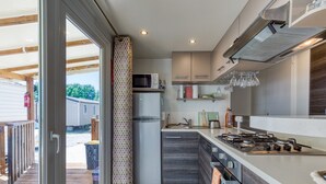 Cozinha moderna com micro-ondas, frigorífico e fogão a gás.