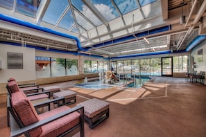 A spacious indoor pool area with seating and a waterfall feature. - On the River, Downtown Ski In/Out Location (Breckenridge)