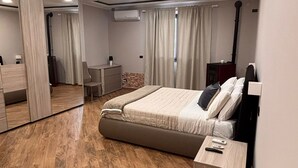 Une chambre moderne avec un grand lit, des tables de chevet, une armoire et un miroir.