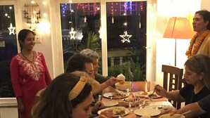Comedor con una mesa dispuesta para una comida, rodeado de ventanas decoradas con luces de cuerda.