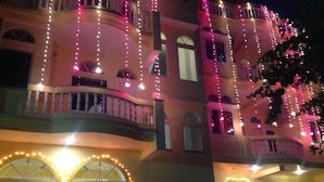 Un edificio de varios pisos con balcones, arcos y luces colgantes.