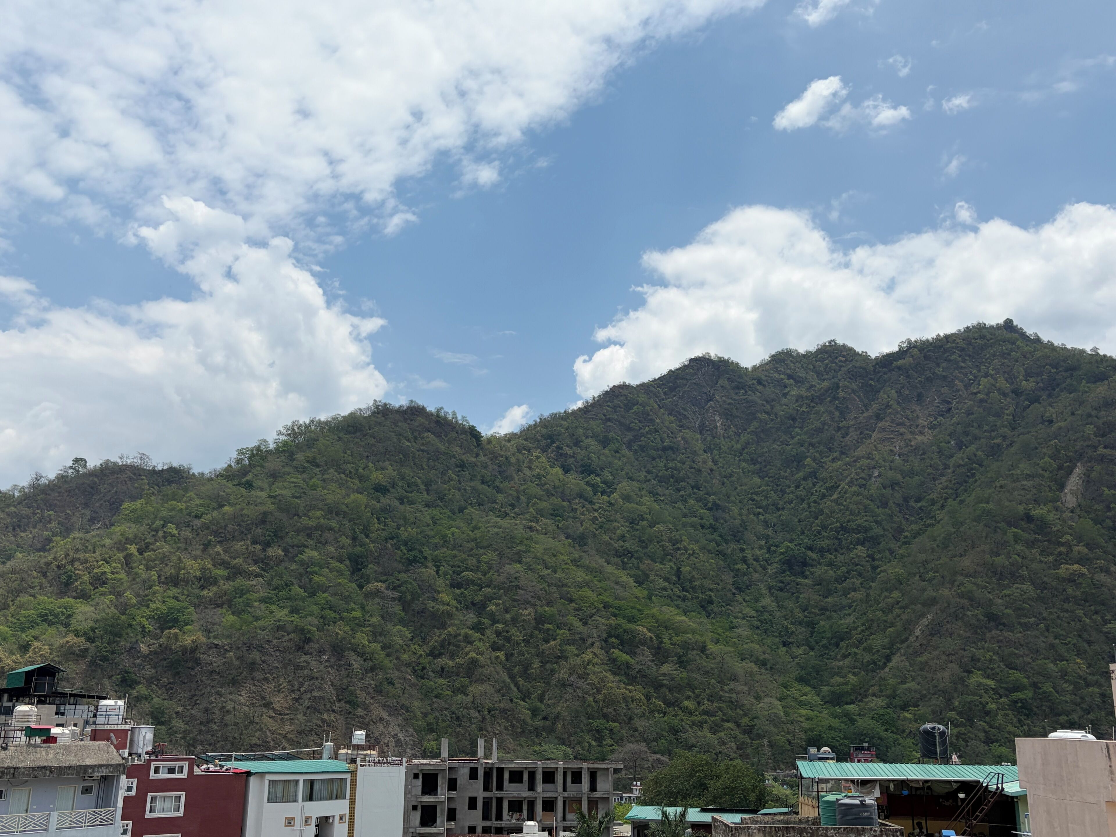A mountainous landscape with a building in the foreground.