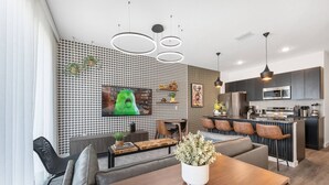 Uma cozinha moderna com ilha central, eletrodomésticos embutidos e iluminação pendente.
