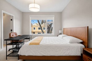 Ein Schlafzimmer mit Bett, Schreibtisch und Stuhl.